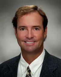 Tyson Hayward, President and CEO of Spinnaker Financial, in a dark blazer and striped tie